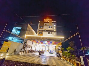 A hotel with a signboard, a covered entrance, and a tiled pavement. - Hotel Shree Raghunandan Palace (Ujjain)
