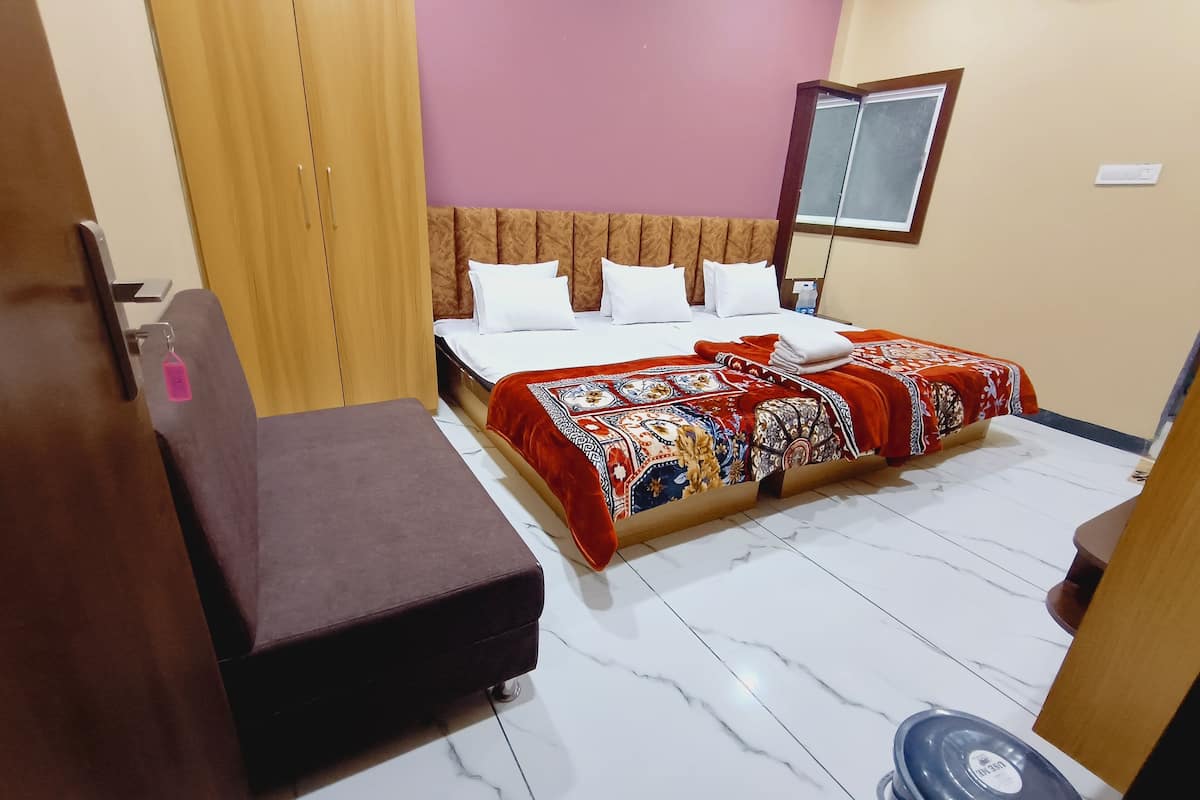 A hotel room with a bed, a bench, a mirror, and a window.