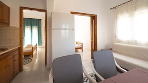 A compact room with a kitchenette, a dining area, a sofa, and a bed. - Erato Apartment 1 by RentalsPro - Nea Plagia Halkidiki (Plagia)