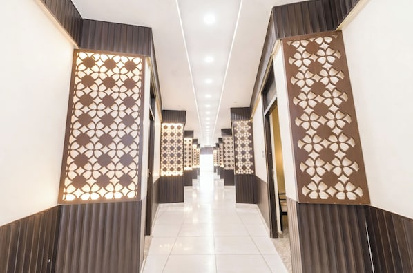 Un pasillo con paneles decorativos en la pared, iluminación empotrada y suelo de baldosas.