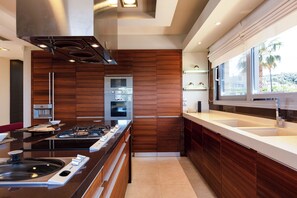 Una cocina moderna con una isla central, electrodomésticos de acero inoxidable y armarios de madera.
