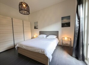 A modern bedroom with a large bed, bedside lamps, a view of the city, and a large window with curtains. - Natuurhuisje Abcoude - Groen Verblijf Buitenhuis (Abcoude)