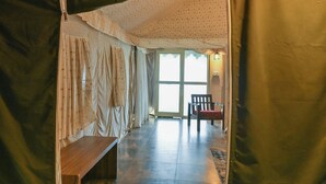 Una habitación con un banco, una silla y un ventanal grande.