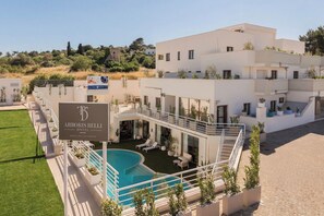 A modern hotel with a pool, outdoor seating, and a sign for the ABORIS BELLI HOTEL. - ARBORIS BELLI HOTEL  (Alberobello)
