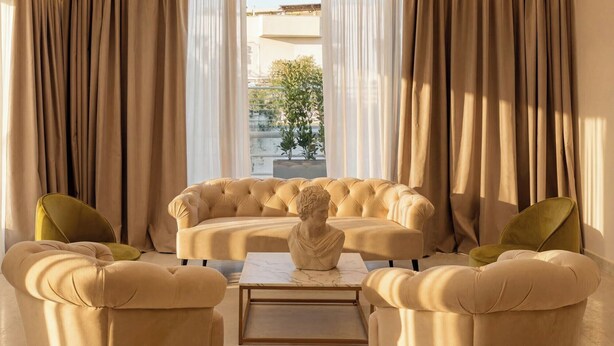 A luxurious living room with a sofa, two armchairs, a marble coffee table, and a bust sculpture. - ARBORIS BELLI HOTEL  (Alberobello)