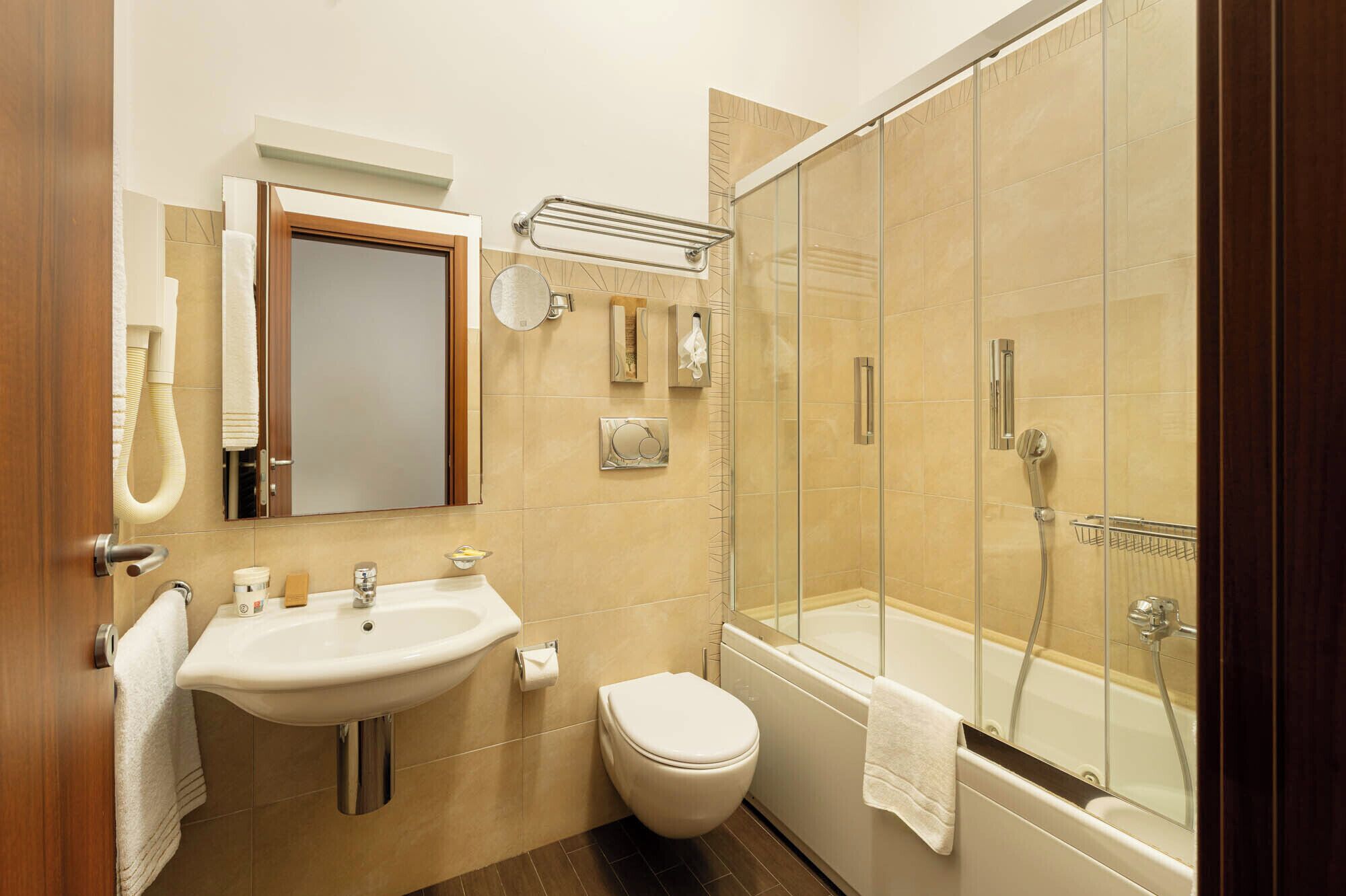 A bathroom with a sink, toilet, and glass-enclosed shower.