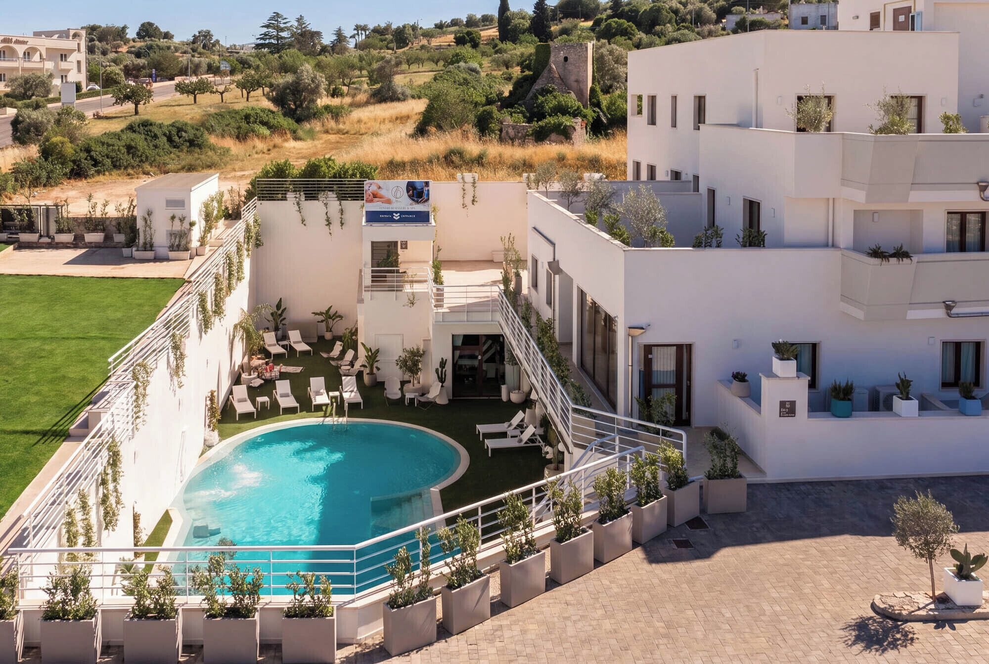 Un hôtel moderne doté d’une piscine, d’un espace extérieur aménagé et offrant une vue sur le paysage environnant.