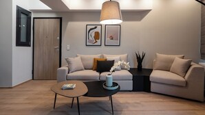 A modern living room with a sofa, coffee table, and artwork on the wall. - THE EDGE Luxurious Penthouse Shared Gym (Kallithea)