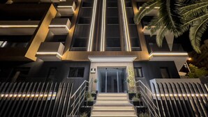 A modern building with a prominent entrance, a staircase leading up to the door, and a sign with illuminated letters. - THE EDGE Luxurious Penthouse Shared Gym (Kallithea)