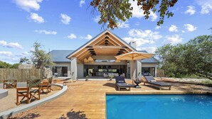 A modern house with a pool, outdoor seating, and a covered patio. - Kimbilia Luxury Villa  (Hoedspruit)
