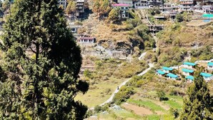 Un pueblo montañoso con campos en terrazas y edificaciones.