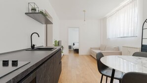 Une cuisine moderne avec un plan de travail foncé, un robinet noir et un plancher en bois.