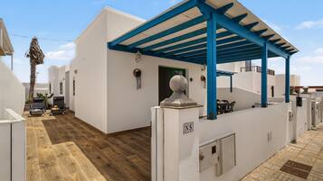 Edificio blanco con estructura de techo azul, suelo de madera y una puerta con la leyenda 'N5'.