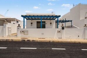 A modern building with a white facade, blue accents, and a covered entrance.
