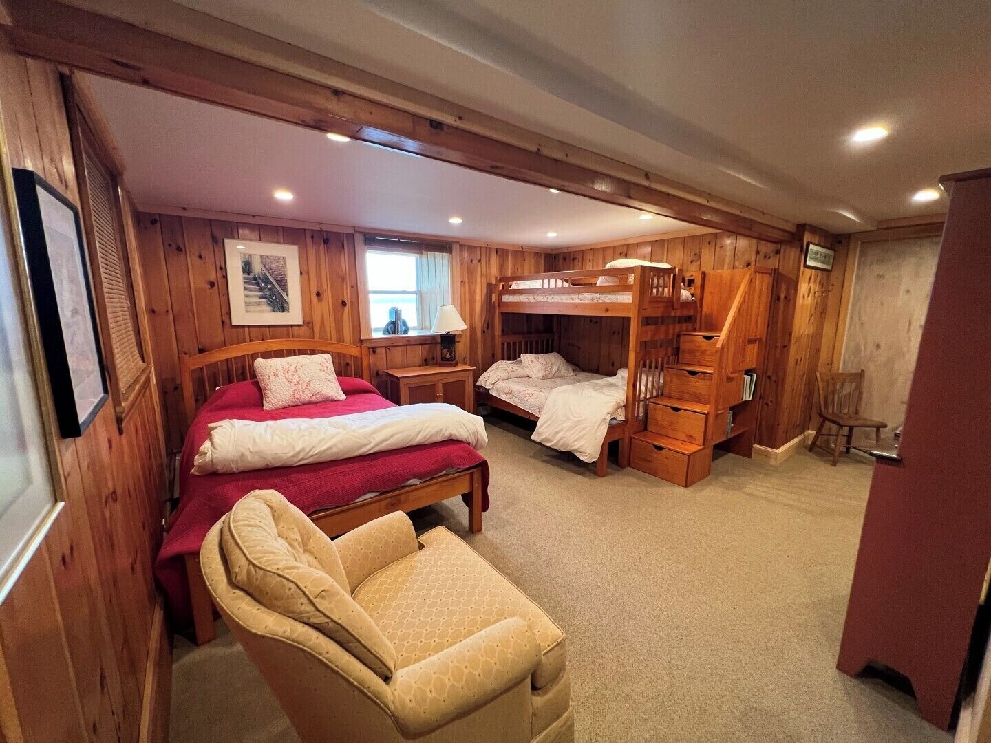 Une chambre avec deux lits superposés, une chaise, un bureau et une fenêtre.