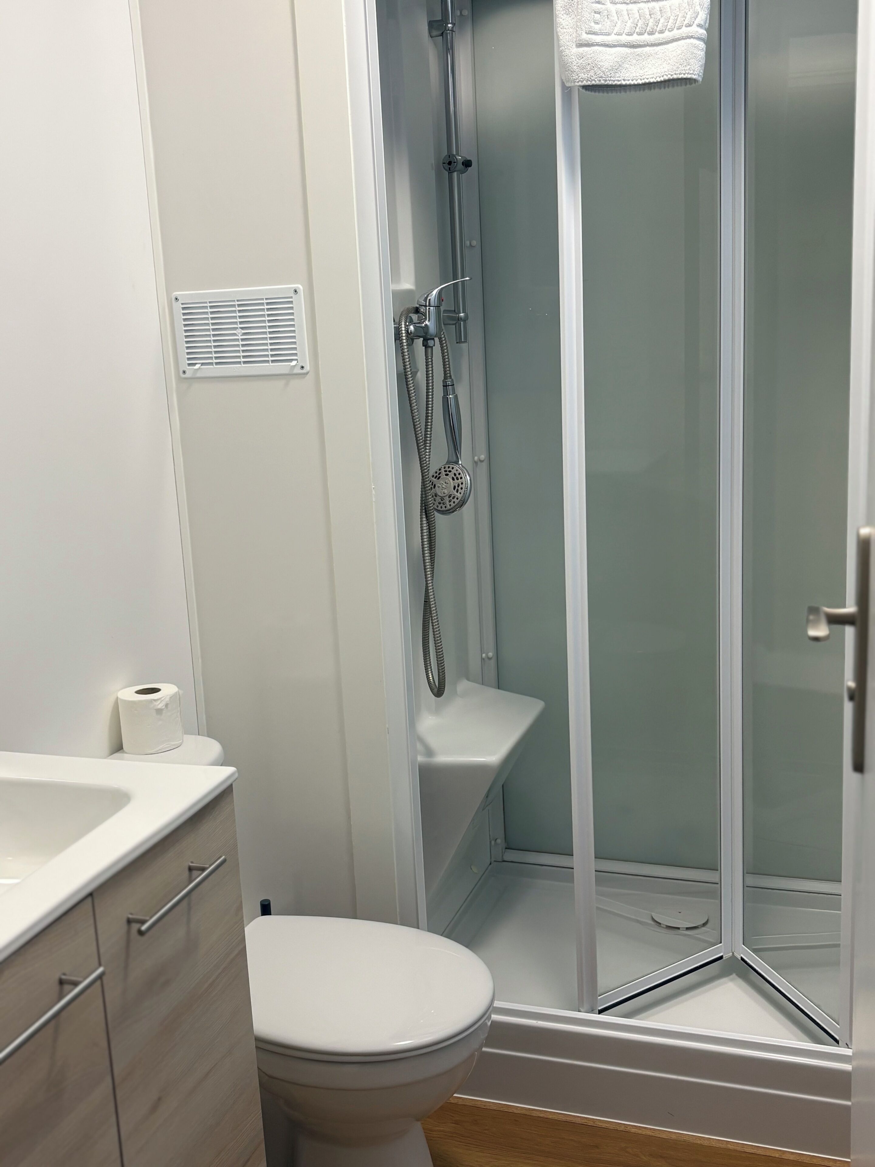 Une salle de bain comprenant des toilettes, un espace douche et un lavabo.