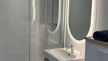 Superior tweepersoonskamer | Badkamer | Een douche, handdoeken, zeep, shampoo