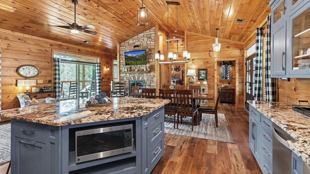 A spacious kitchen with a central island, wooden ceiling, and modern appliances. - New Cabin w/view|Hot tub|Himalayan Salt Room|Walk to Downtown Gatlnburg (GATLINBURG)