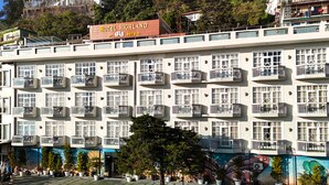 Ein Hotel mit mehreren Balkonen, Wandgemälde und Sitzgelegenheiten im Freien.