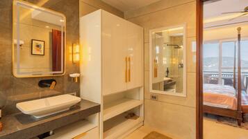 A modern bathroom with a large mirror, a white vanity, and a shower area.