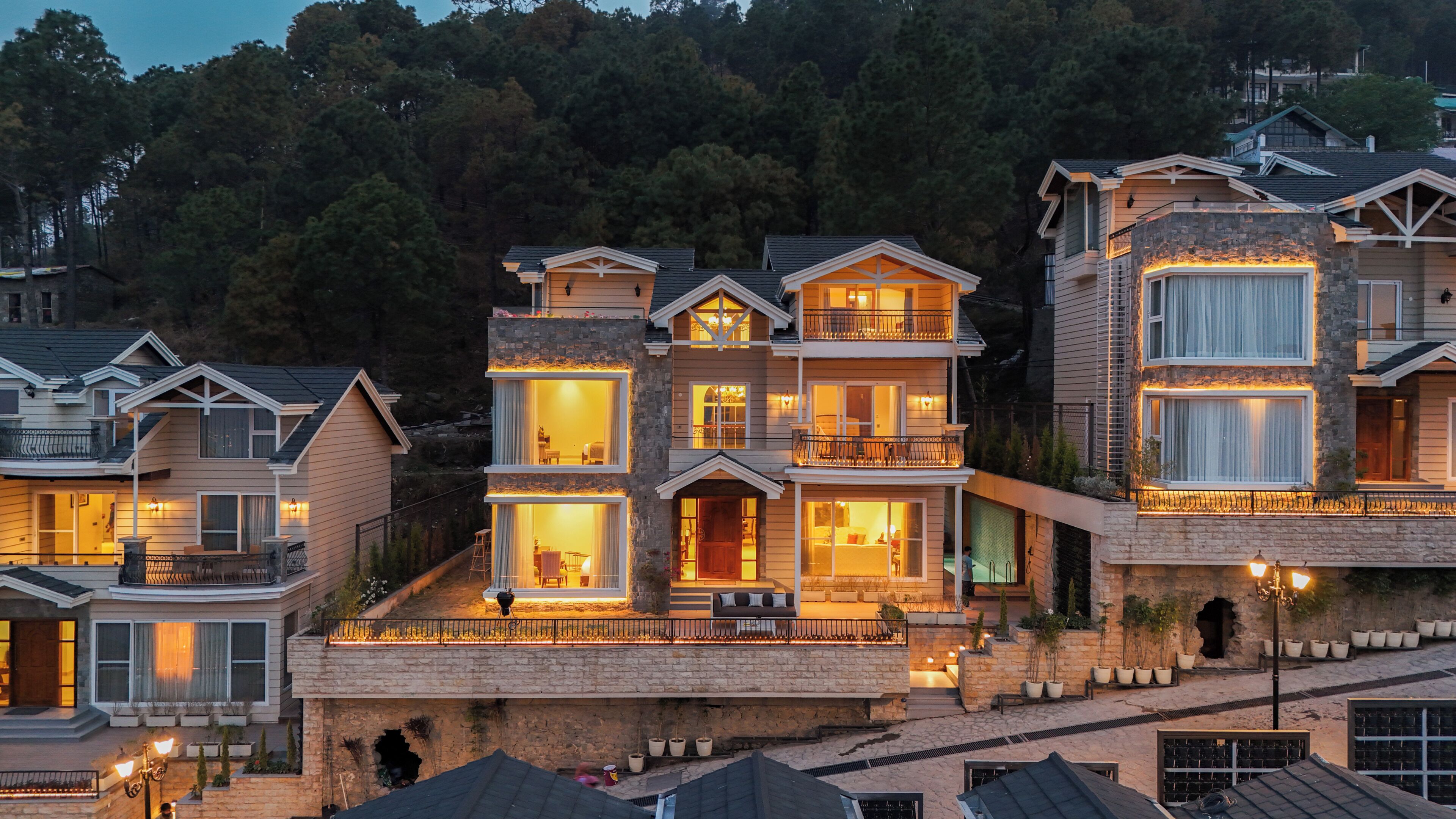 A multi-story house with a stone facade, multiple balconies, and large windows.