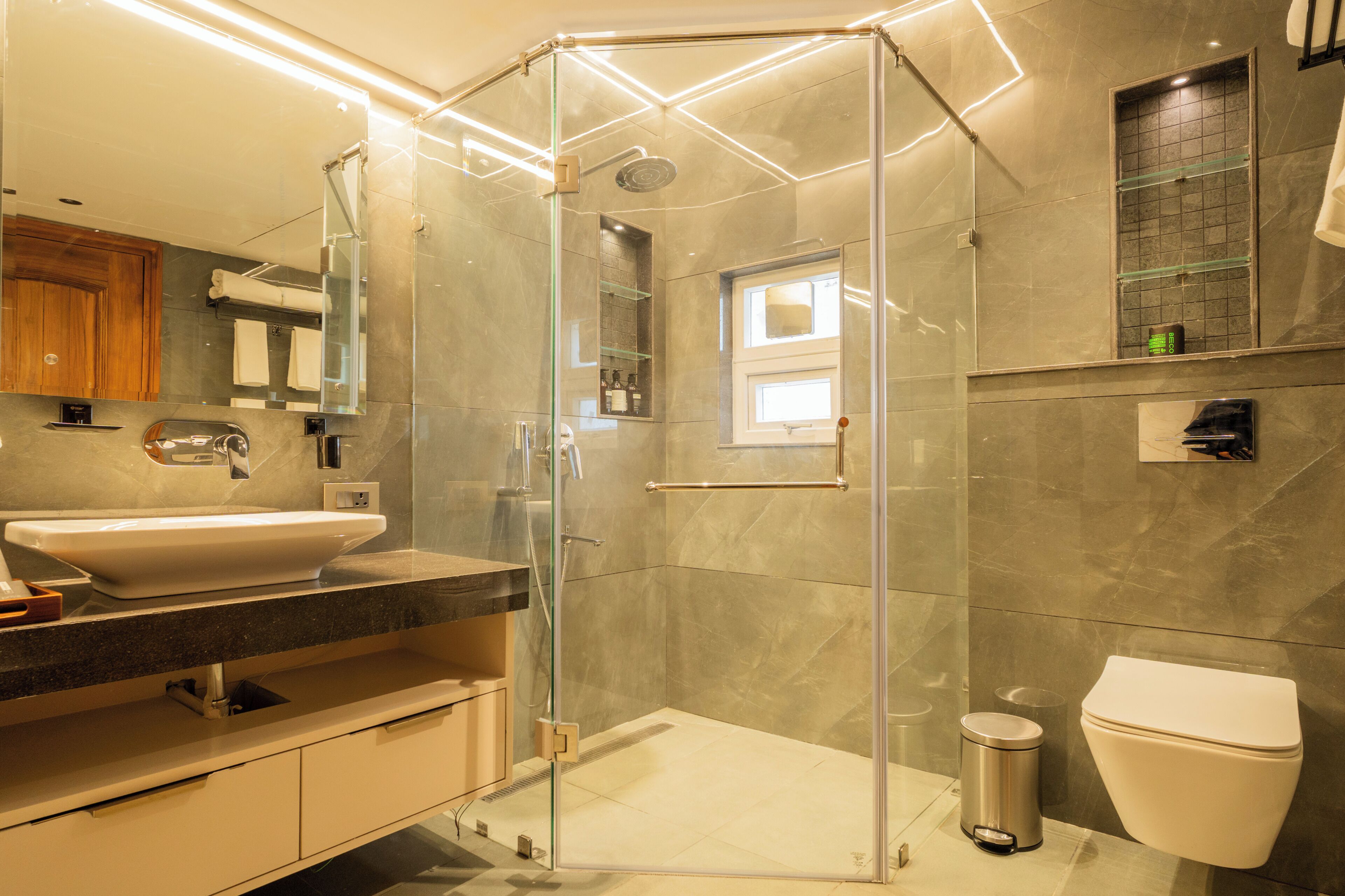 A modern bathroom with a glass-enclosed shower, a sink, and a toilet.