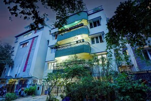 A multi-story building with balconies, a gated entrance, and surrounding greenery. - Alaya Stays Saffron Breeze Apartment  (Bengaluru)