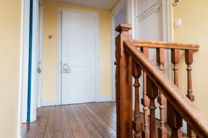 Un escalier en bois avec une porte blanche en haut.