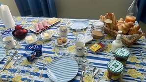 Una tavola imbandita per la colazione, con piatti, posate e cibo.