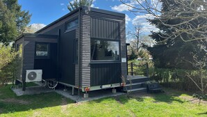 A compact, modern cabin with a satellite dish, large windows, and a small porch area. - Cozy Tiny House "Spree-Maus" Family-friendly - only 50m to the Spree (Grünheide (Mark))