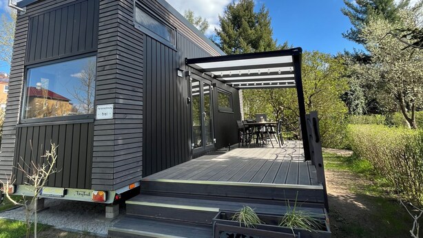 A modern, compact building with a deck, a bench, and a pergola. - Cozy Tiny House "Spree-Maus" Family-friendly - only 50m to the Spree (Grünheide (Mark))