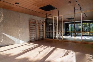 A spacious room with wooden flooring, large windows, and exercise equipment. - Stylish Apartment | Garden | Parking | Gym. (Katowice)
