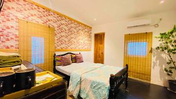 Un dormitorio con cama, mesita de noche con lámpara, ventana con persianas y aire acondicionado instalado en la pared.