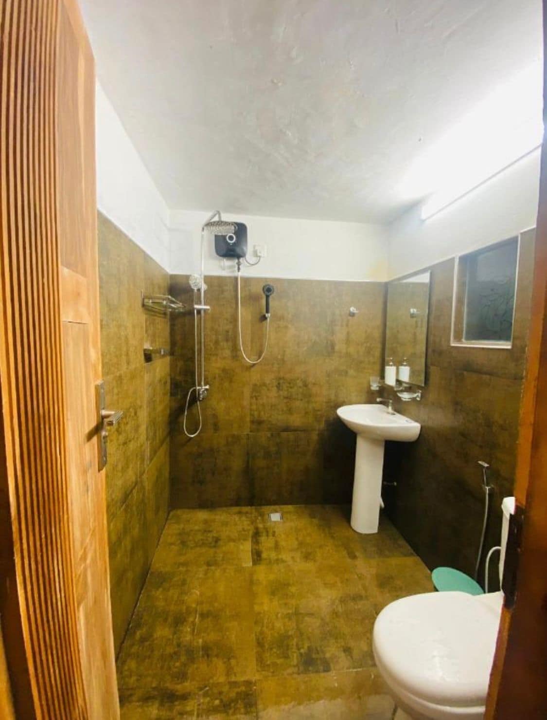 A bathroom with a shower, sink, and toilet.