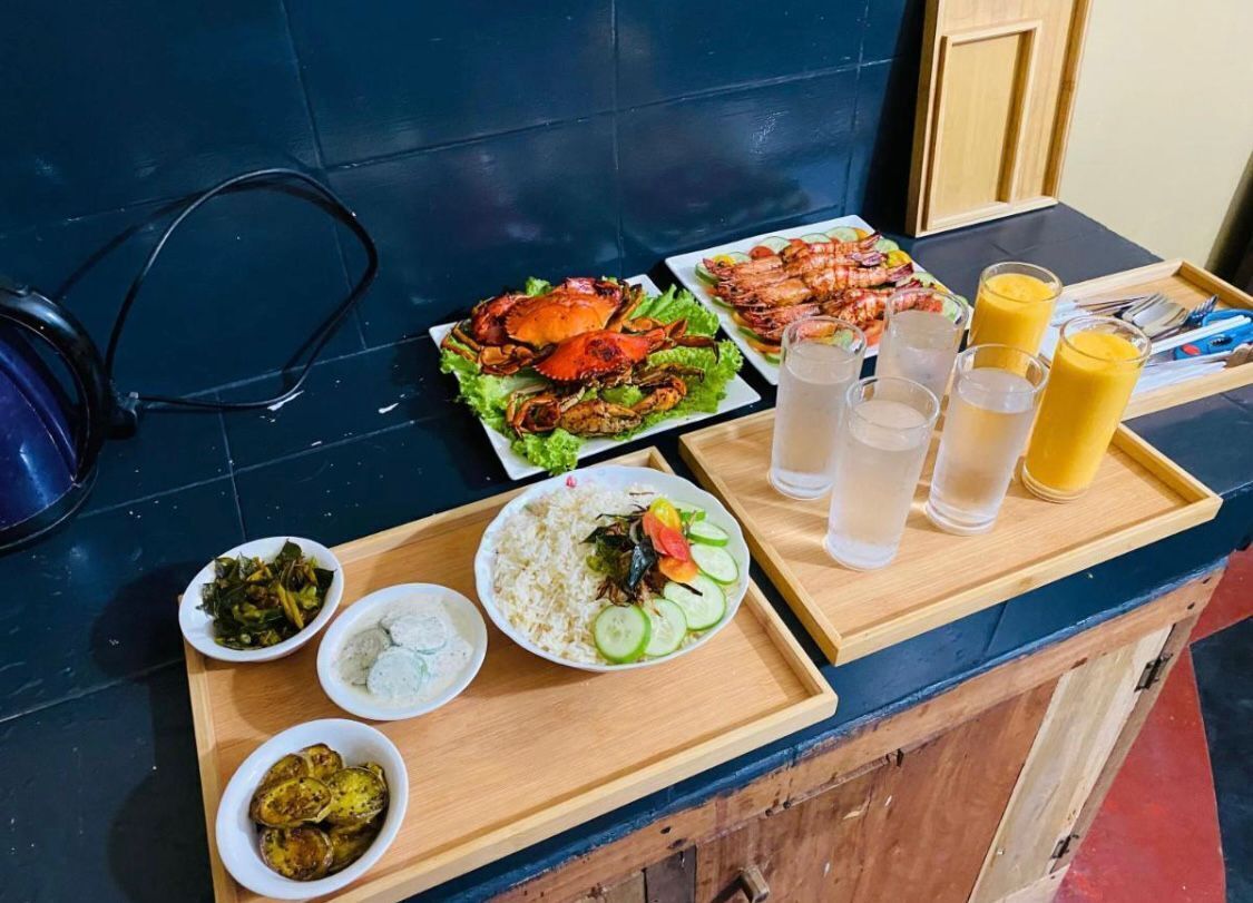 Une table à manger avec différents plats, des verres et un plateau.