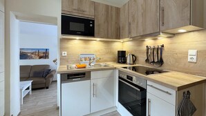 Ett modernt kök med en mikrovågsugn från Bosch, en kaffebryggare och en diskmaskin.
