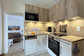 A modern kitchen with a Bosch microwave, a coffee maker, and a dishwasher. - Fischerhaus Toppweg 3 Apartment 5 Terrace 20m from the harbor, parking, WLAN (Neuharlingersiel)