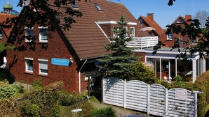En byggnad i tegel med en skylt där det står ”Fischerhaus Immobilien – lägenheter”.