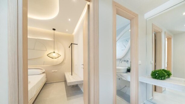 Un bagno moderno con uno specchio grande, un lavandino e una zona doccia.