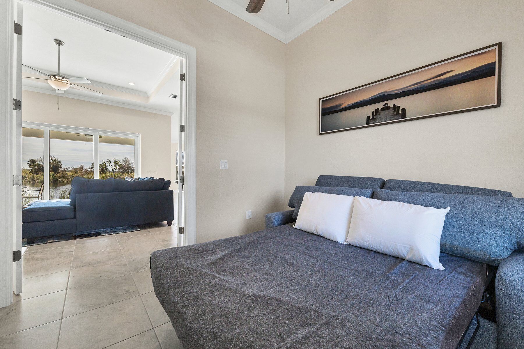 Une chambre à coucher avec un lit, un canapé et un tableau accroché au mur.