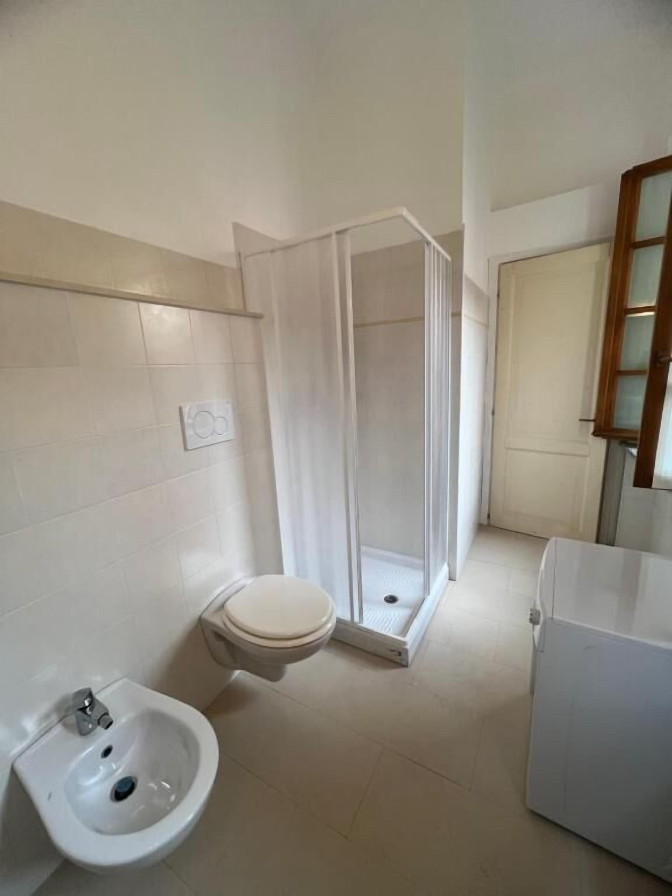 Ein Badezimmer mit Toilette, Bidet und Duschkabine.