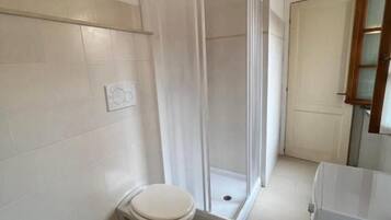 Ein Badezimmer mit Toilette, Bidet und Duschkabine.