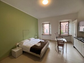 A bedroom with a bed, bedside table, and a window. - Luma Novara (Novara)