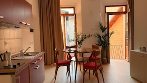 A compact kitchen with a dining area, a potted plant, and a view of the outside. - Luma Novara (Novara)