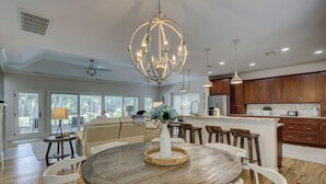 A spacious kitchen with wooden cabinets, a central island, and pendant lighting. - 7 Rum Row - Private Pool, Golf Views & Walk to the Beach in Palmetto Dunes (Hilton Head Island)