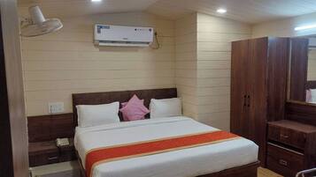 Un dormitorio con cama, mesita de noche, lámpara, armario y aire acondicionado.