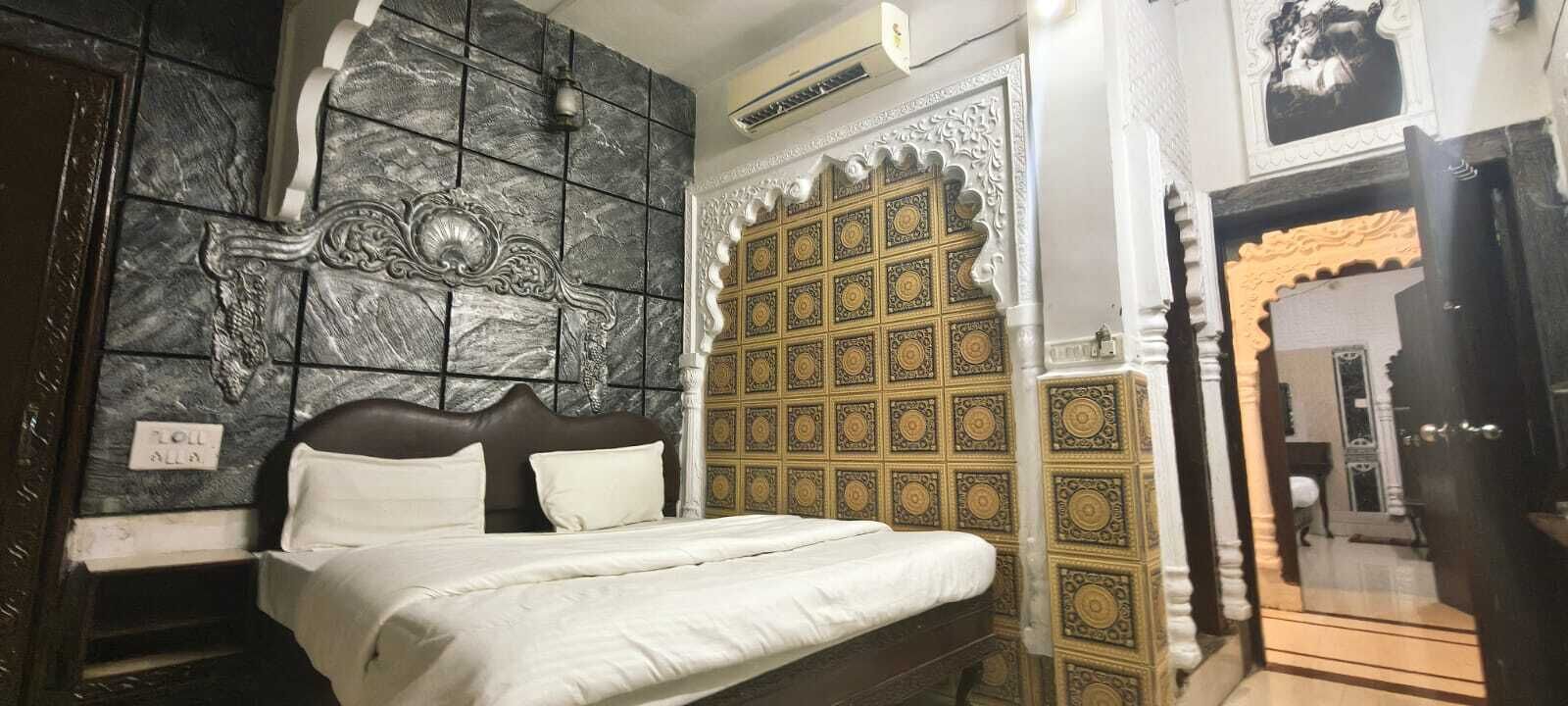 Una habitación con cama, un detalle decorativo en la pared y una puerta con diseño.