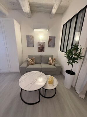 A modern living room with a grey sofa, two marble tables, and a potted plant. - Beautiful Charrons 3 - Large new studio, 50 m from the harbor, in the center of Saint-Tropez (Saint-Tropez)
