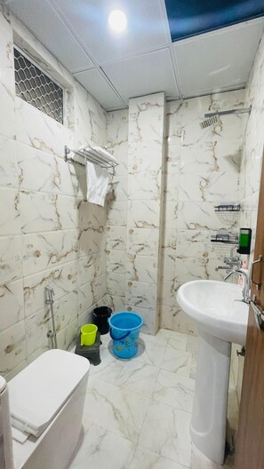 Bañera con ducha, toallas, jabón, shampoo