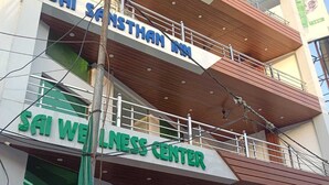 A multi-story building with signage for 'Sainthan Inn' and 'Sai Wellness Center.' - sai sansthan inn (Lucknow)